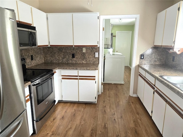 kitchen featuring sink, white cabinetry, stainless steel appliances, light hardwood / wood-style floors, and backsplash