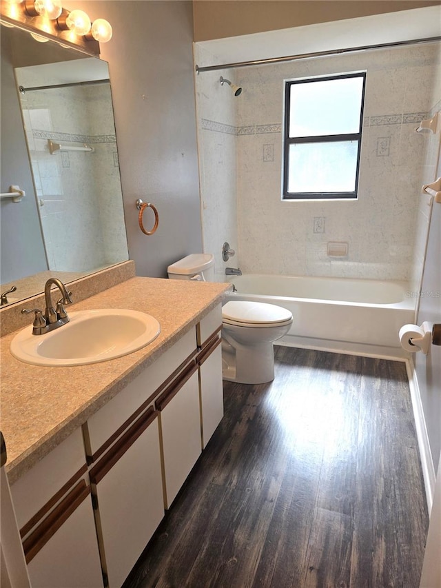 full bathroom featuring tiled shower / bath combo, wood-type flooring, vanity, and toilet