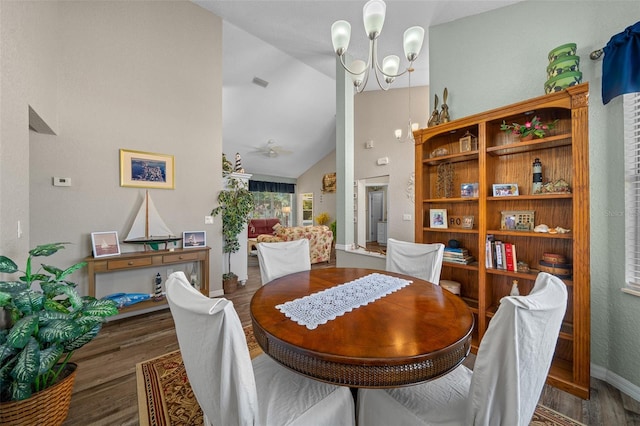 dining space with vaulted ceiling, hardwood / wood-style floors, and a chandelier