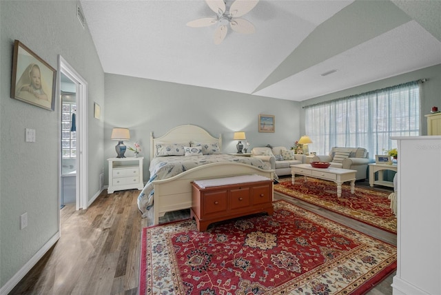 bedroom with ceiling fan, lofted ceiling, wood-type flooring, and a textured ceiling