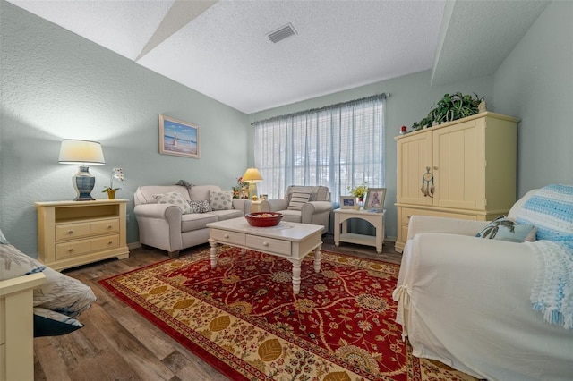 living room with dark hardwood / wood-style floors and a textured ceiling