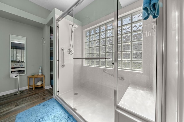 bathroom featuring a shower with door and hardwood / wood-style flooring