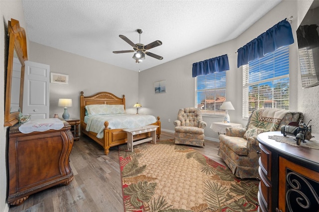 bedroom with ceiling fan, hardwood / wood-style floors, and a textured ceiling