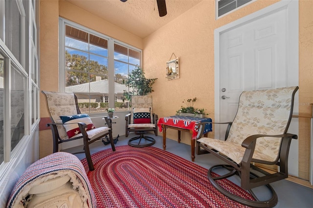 exterior space featuring ceiling fan and a textured ceiling