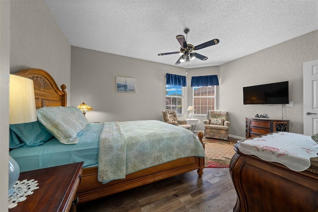 bedroom with ceiling fan, a textured ceiling, and dark hardwood / wood-style flooring