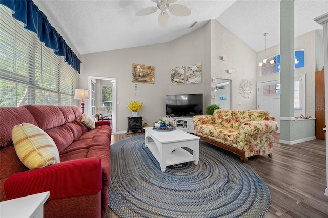 living room featuring high vaulted ceiling, wood-type flooring, ceiling fan with notable chandelier, and a textured ceiling