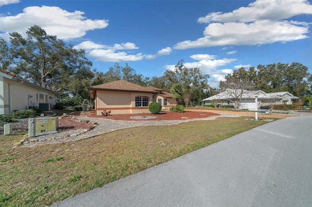 view of front of house featuring central AC and a front yard