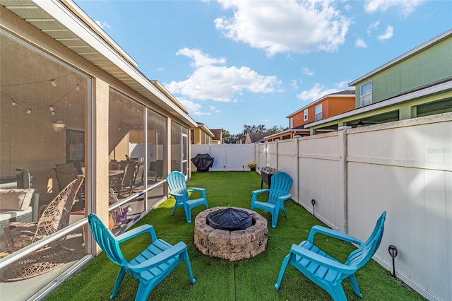 view of yard with a sunroom and an outdoor fire pit