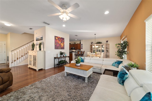 living room featuring dark wood-type flooring and ceiling fan