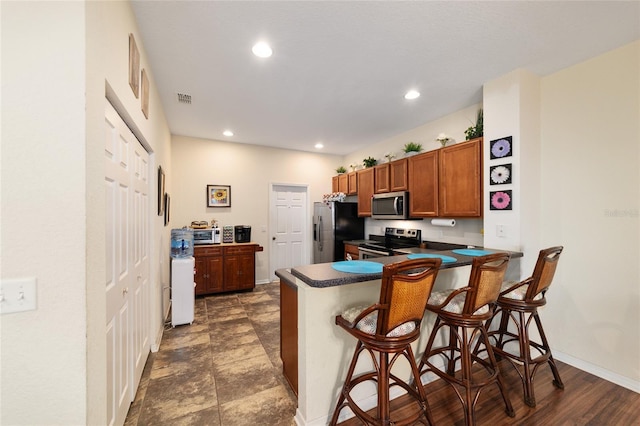 kitchen featuring a kitchen breakfast bar, stainless steel appliances, and kitchen peninsula