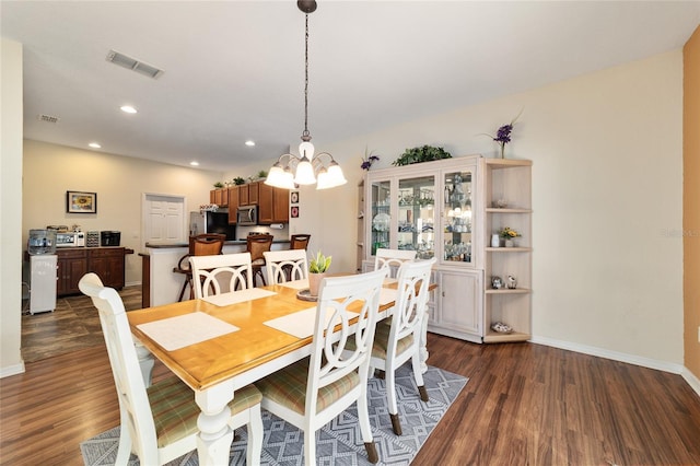 dining room featuring a notable chandelier and dark hardwood / wood-style flooring