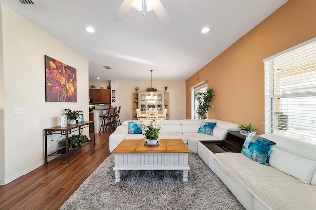 living room featuring dark wood-type flooring, a wealth of natural light, and ceiling fan