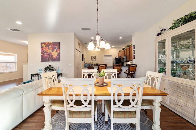 dining space with an inviting chandelier and dark hardwood / wood-style floors