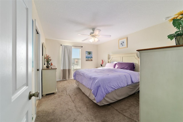 carpeted bedroom with ceiling fan and a textured ceiling