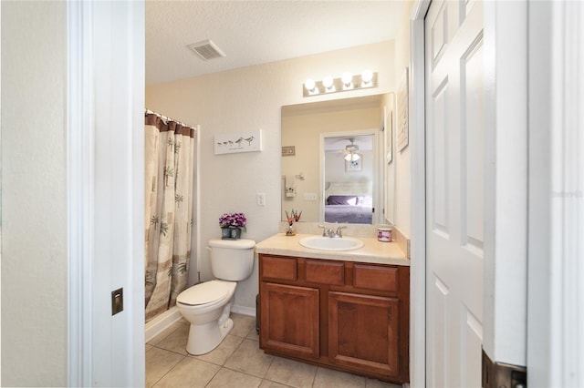 bathroom featuring tile patterned flooring, vanity, walk in shower, toilet, and a textured ceiling