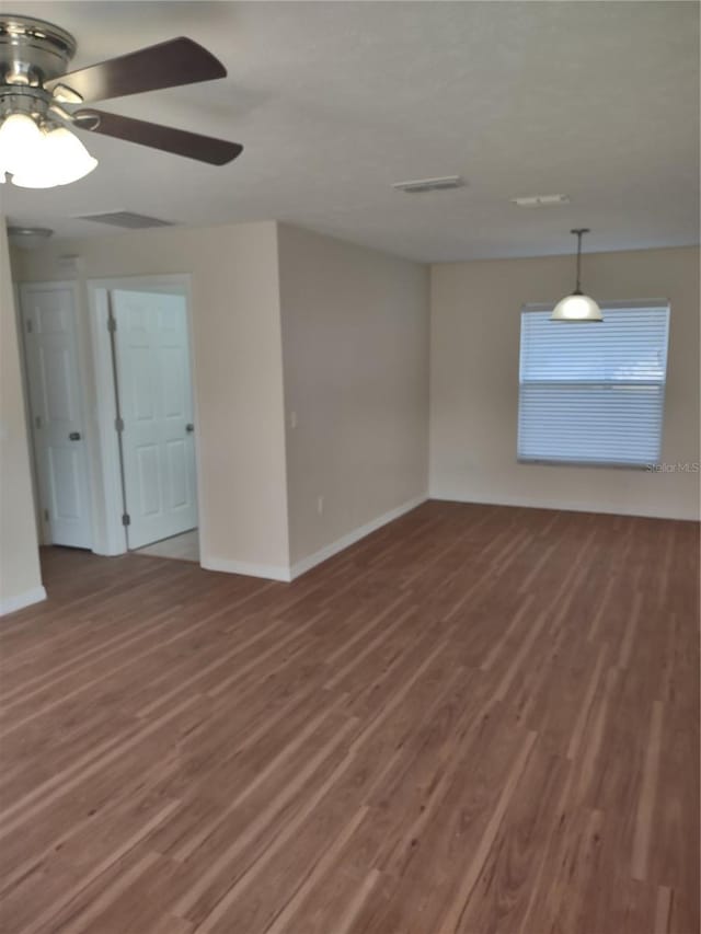 unfurnished room with ceiling fan and dark hardwood / wood-style floors