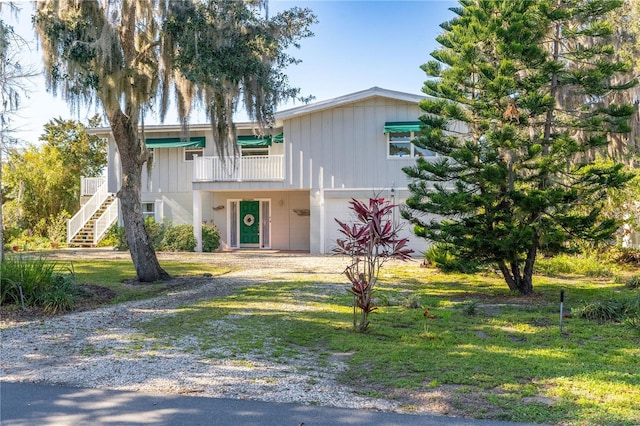 view of front of home with a front lawn, a garage, and a balcony