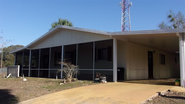 view of side of property featuring a carport and a sunroom