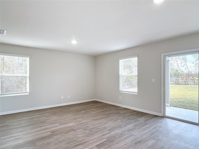 spare room featuring light hardwood / wood-style floors and a wealth of natural light