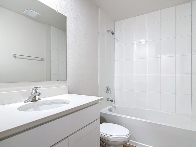 full bathroom featuring vanity, tiled shower / bath combo, and toilet