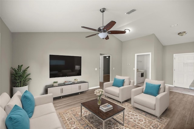 living room featuring hardwood / wood-style flooring, vaulted ceiling, and ceiling fan