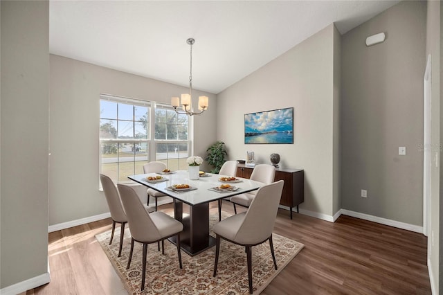 dining area featuring an inviting chandelier, hardwood / wood-style floors, and vaulted ceiling