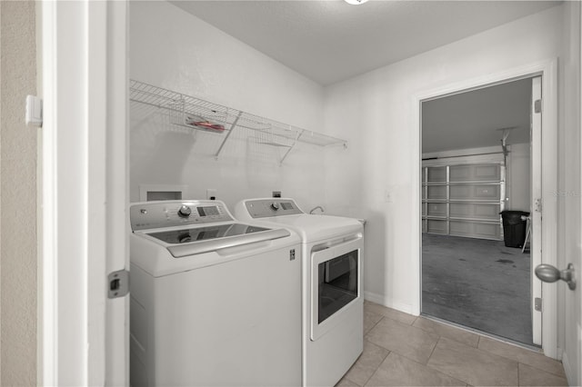 clothes washing area featuring light tile patterned flooring and separate washer and dryer