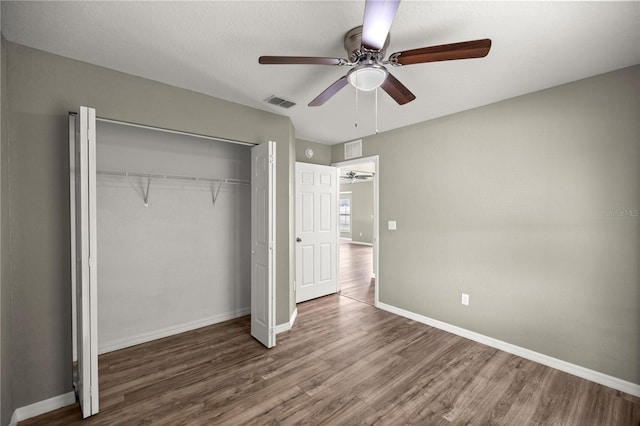 unfurnished bedroom featuring hardwood / wood-style flooring, ceiling fan, and a closet