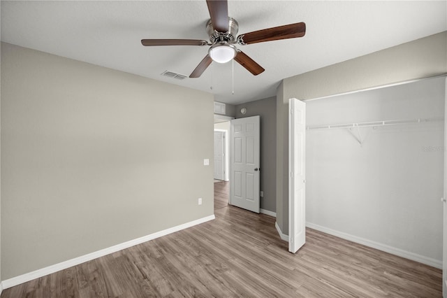 unfurnished bedroom with ceiling fan, a closet, and light wood-type flooring