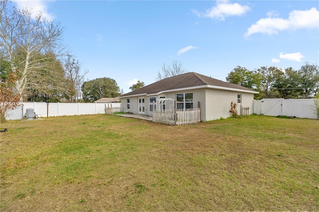 back of house featuring a patio area and a lawn