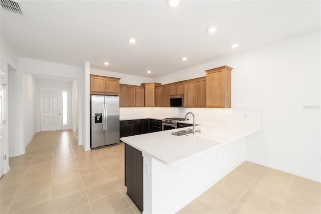 kitchen featuring stainless steel appliances, kitchen peninsula, sink, and light tile patterned floors