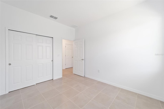 unfurnished bedroom with light tile patterned flooring and a closet