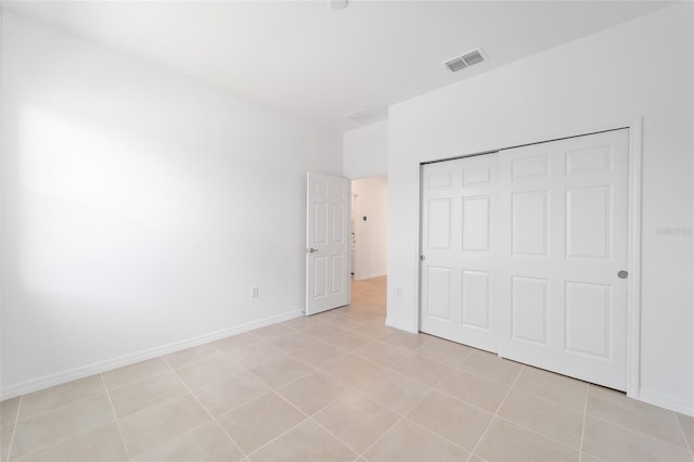 unfurnished bedroom featuring light tile patterned flooring and a closet