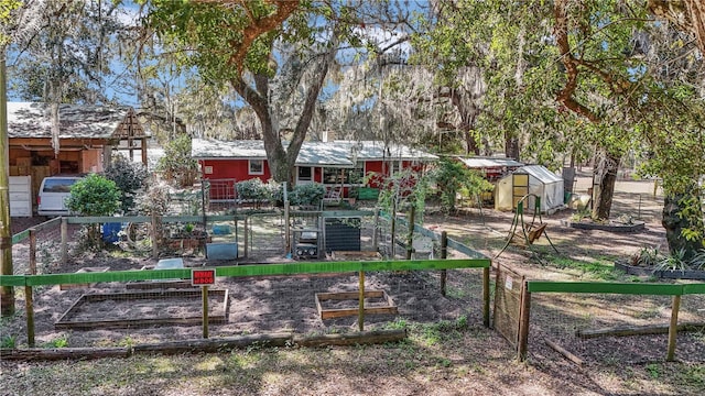 exterior space featuring fence, a vegetable garden, and an outdoor structure