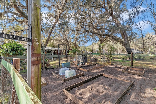 view of yard with a vegetable garden and fence