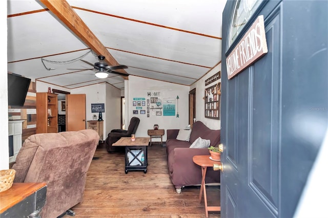 living area with vaulted ceiling with beams, ceiling fan, and wood finished floors