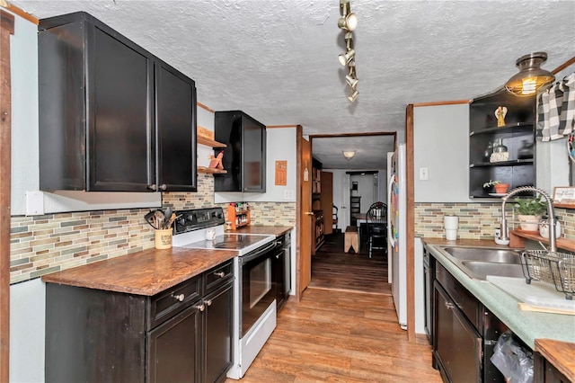 kitchen featuring a textured ceiling, white appliances, a sink, light wood-style floors, and open shelves