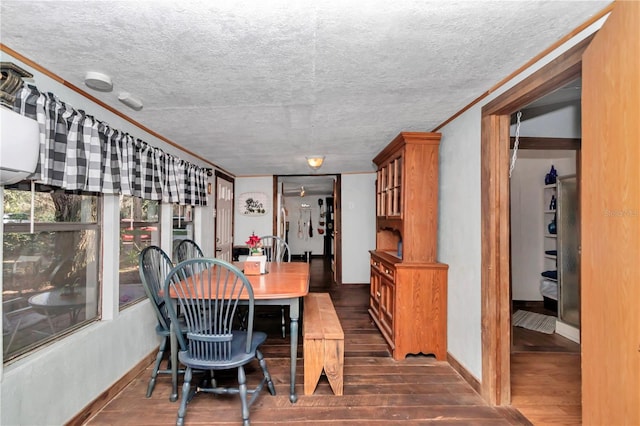 dining space featuring dark wood-style floors, baseboards, and a textured ceiling