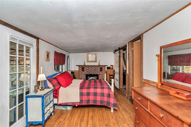 bedroom featuring ornamental molding, wainscoting, and wood finished floors