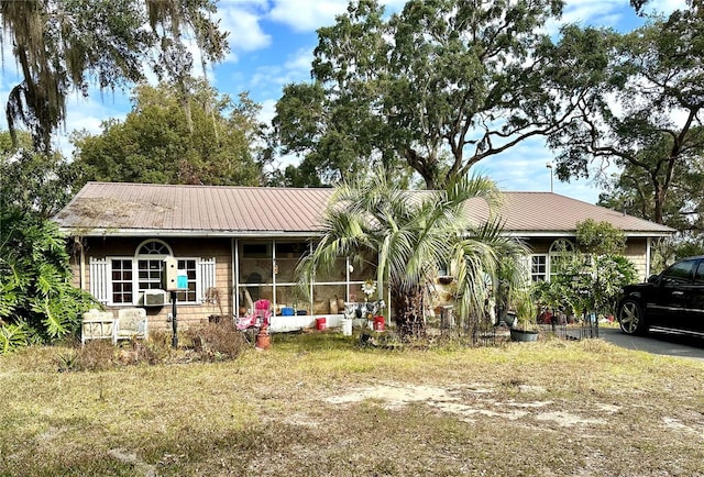 view of front of home featuring a front lawn and a sunroom