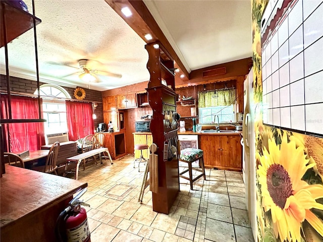 kitchen featuring ceiling fan, sink, cooling unit, and a textured ceiling