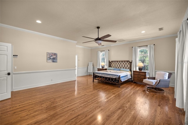 bedroom with hardwood / wood-style flooring, ceiling fan, ornamental molding, and a textured ceiling