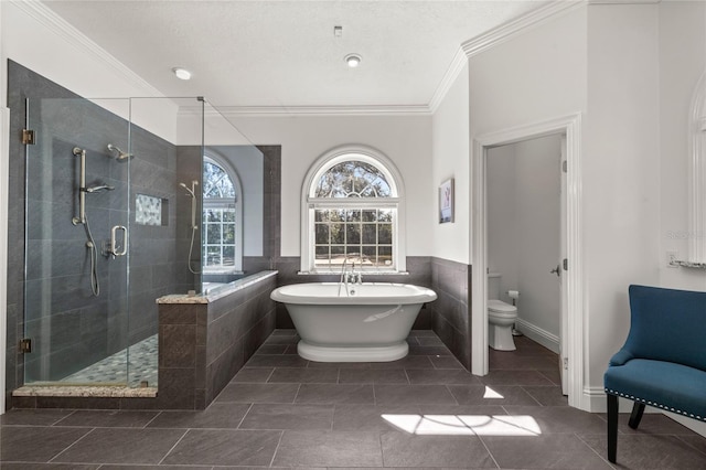 bathroom with tile patterned flooring, tile walls, ornamental molding, independent shower and bath, and toilet