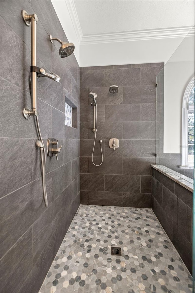 bathroom with ornamental molding and a tile shower