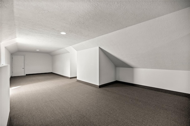 bonus room featuring vaulted ceiling, carpet flooring, and a textured ceiling