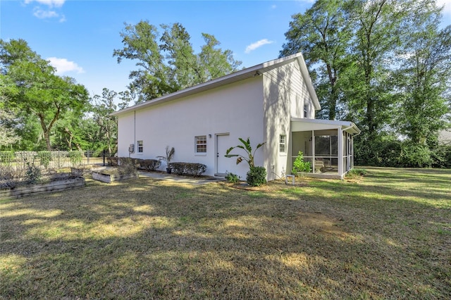 view of property exterior with a yard and a sunroom