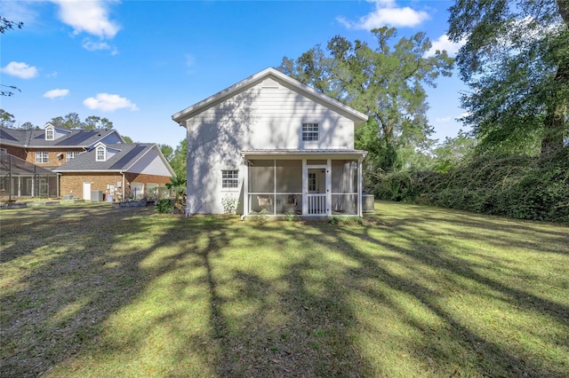 rear view of property with a yard and a sunroom