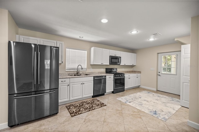 kitchen featuring sink, stainless steel appliances, white cabinets, and light tile patterned flooring