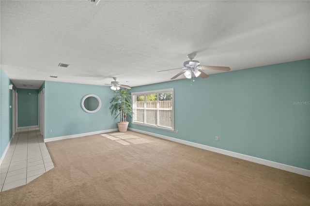 unfurnished room with light carpet, ceiling fan, and a textured ceiling