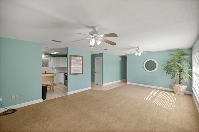 unfurnished living room with light carpet and a textured ceiling